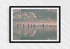 Beach Fever, a colour photographic print  in a black frame depicting the sky and people reflected on Saunton Sands.