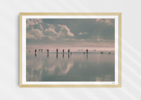Beach Fever, a colour photographic print  in a wood frame depicting the sky and people reflected on Saunton Sands.