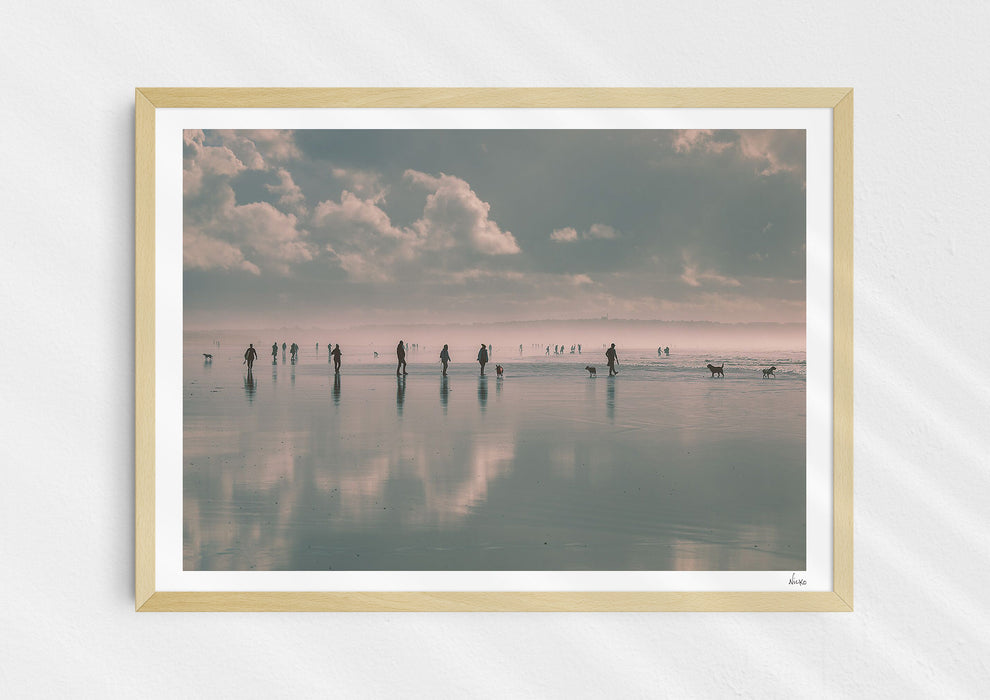 Beach Fever, a colour photographic print  in a wood frame depicting the sky and people reflected on Saunton Sands.