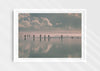 Beach Fever, a colour photographic print  in a white frame depicting the sky and people reflected on Saunton Sands.