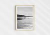 Clear To Land, a black-and-white photo print of surfers on the beach at Polzeath, Cornwall in a wood frame.