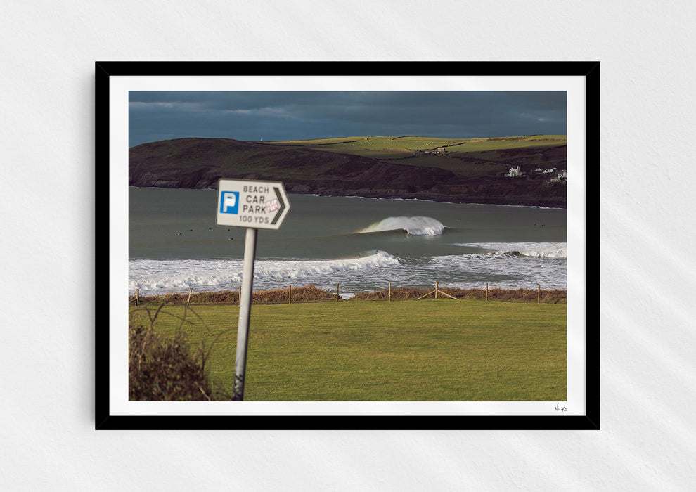 Delivery Bowls, a fine art photo print of a barrelling wave at Croyde Bay in Devon in a black frame.