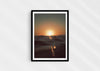 Gold Stripe, a colour photographic print of the sun at the ocean horizon at Croyde Bay, Devon in a black frame.