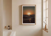 Gold Stripe, a colour photographic print of the sun at the ocean horizon at Croyde Bay, Devon in a frame on a bathroom wall.