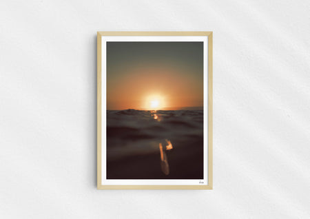 Gold Stripe, a colour photographic print of the sun at the ocean horizon at Croyde Bay, Devon in a wood frame.