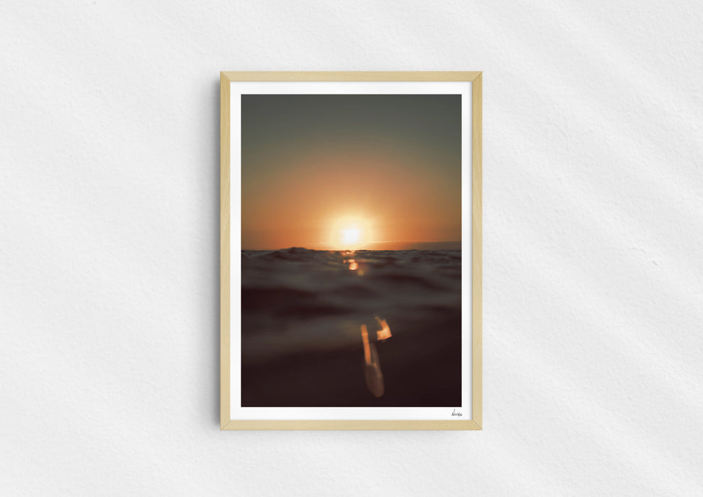 Gold Stripe, a colour photographic print of the sun at the ocean horizon at Croyde Bay, Devon in a wood frame.