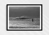 Into the Tempest, a colour photographic print of a surfer facing a breaking wave at Croyde Bay in Devon in a black frame.