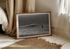 Into the Tempest, a colour photographic print of a surfer facing a breaking wave at Croyde Bay in Devon in a frame in a bedroom.
