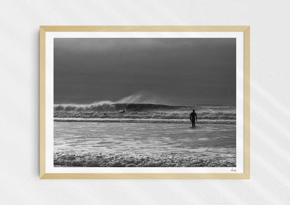 Into the Tempest, a colour photographic print of a surfer facing a breaking wave at Croyde Bay in Devon in a wood frame.