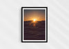 Light in the Deep, a colour photographic print of the sun on the ocean horizon at Porthtowan, Cornwall in a black frame.