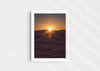 Light in the Deep, a colour photographic print of the sun on the ocean horizon at Porthtowan, Cornwall in a white frame.