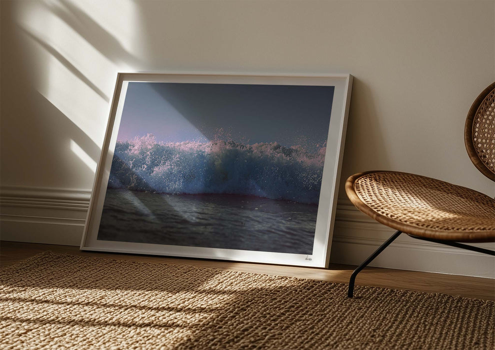 Moments With Colour, a colour photo print capturing a surfer’s eye view of the paddle out at Polzeath in a white frame leaning against a wall.
