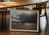 Mutual People, a colour photographic print of surfers walking across sand in northern Scotland in a frame in a dining room.