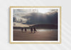 Mutual People, a colour photographic print of surfers walking across sand in northern Scotland in a wood frame.
