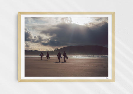 Mutual People, a colour photographic print of surfers walking across sand in northern Scotland in a wood frame.