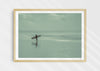 Sea Wanderer, a colour photographic print of a surfer walking across Saunton Sands, Devon in a wood frame.