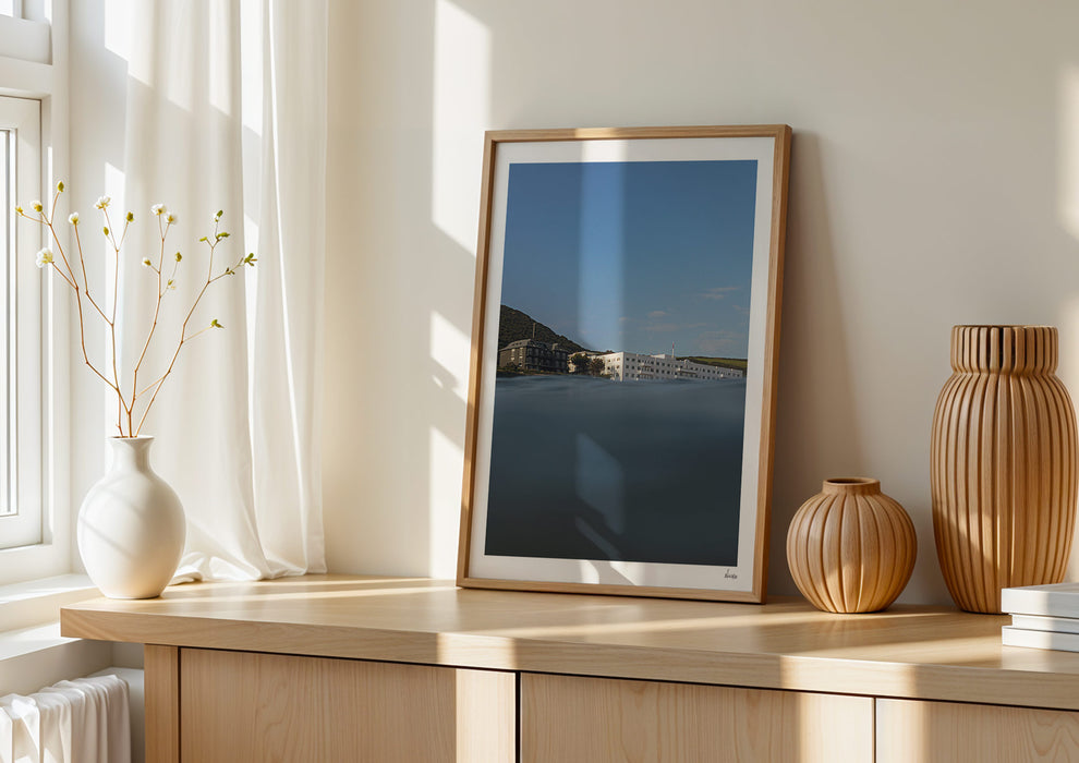 Sea With Hotel Views, a colour photographic print of Saunton Sands Hotel shot from the sea in a frame leaning against a wall.