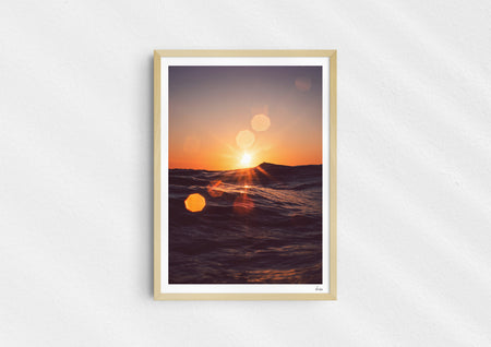 Solar Flare, a colour photographic print of sunlight on the ocean at Porthtowan, Cornwall in a wood frame.