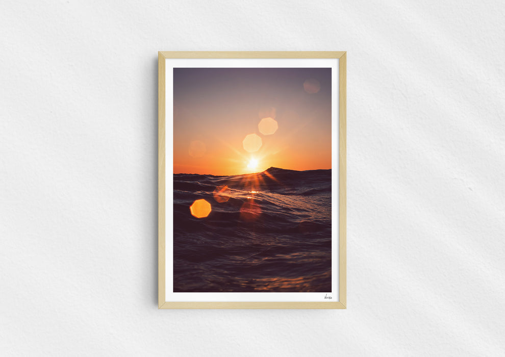 Solar Flare, a colour photographic print of sunlight on the ocean at Porthtowan, Cornwall in a wood frame.