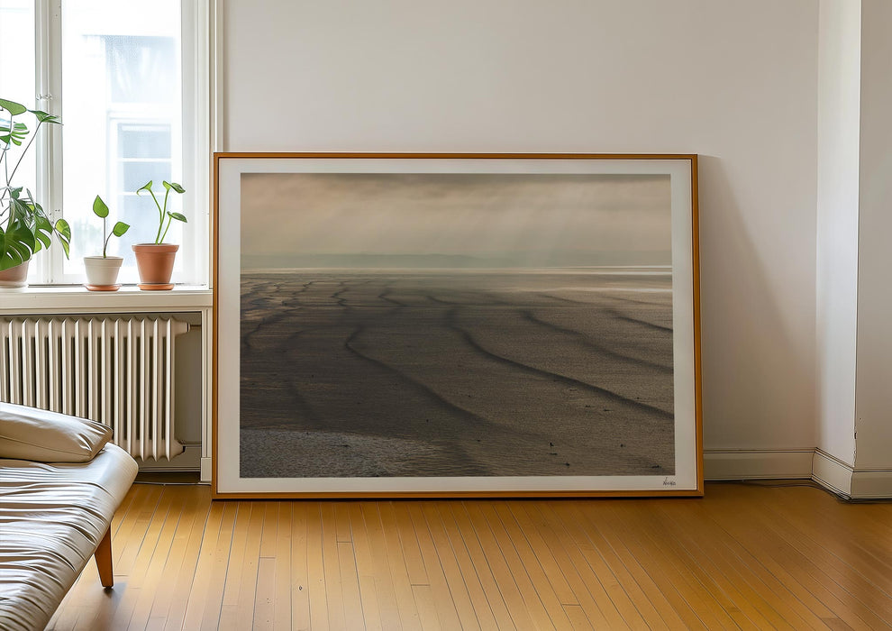 A framed print in a room of Splice Your Lines, a colour photograph depicting lines of swell at Saunton Sands.