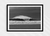 Untamable, a fine art photographic print depicting a barrelling wave with spray at Croyde Bay in Devon in a black frame.