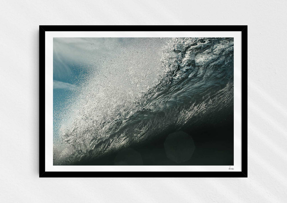 Wild Seductive, a colour photographic print of water droplets suspended over a wave in the Azores in a black frame.