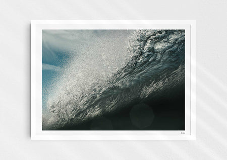 Wild Seductive, a colour photographic print of water droplets suspended over a wave in the Azores in a white frame.